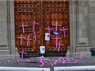 Mujeres saltan valla de Palacio Nacional y colocan cruces en protesta contra feminicidios