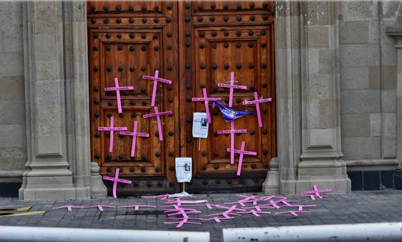Mujeres saltan valla de Palacio Nacional y colocan cruces en protesta contra feminicidios