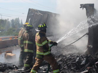Tras volcadura, arde tráiler con envases