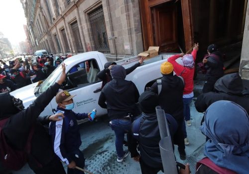 Grupo de normalistas derriban la puerta del Palacio Nacional